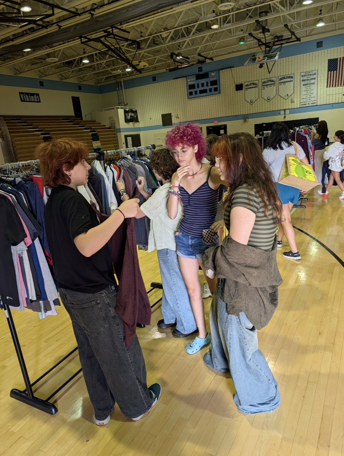 Community members browsing clothing racks during the thrift sale
